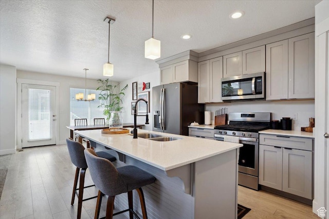 4101 W 1850 N, Lehi, UT 84043 - kitchen featuring a kitchen island with sink, gray cabinets, a chandelier, a sink, and appliances with stainless steel finishes