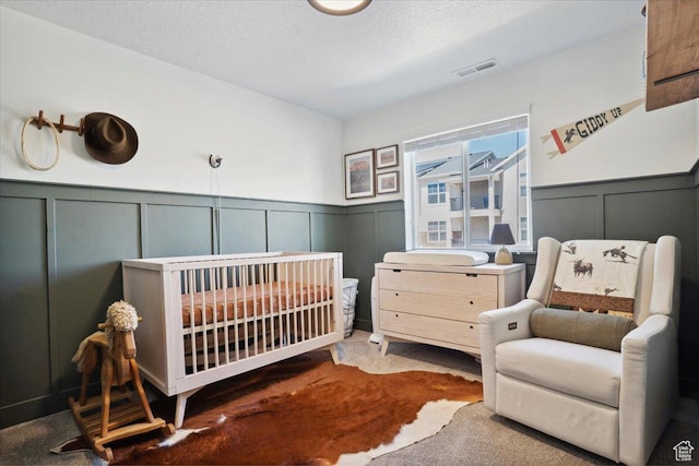 4101 W 1850 N, Lehi, UT 84043 - carpeted bedroom with visible vents, wainscoting, a crib, and a decorative wall