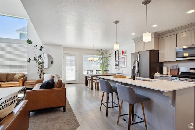 4101 W 1850 N, Lehi, UT 84043 - kitchen with light countertops, appliances with stainless steel finishes, plenty of natural light, and a breakfast bar