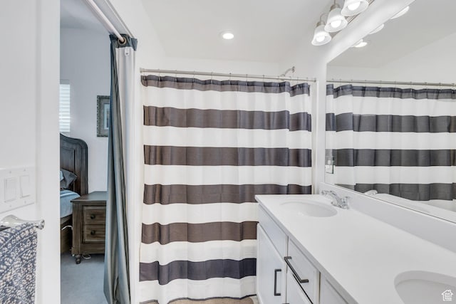bathroom featuring a sink, curtained shower, recessed lighting, and double vanity
