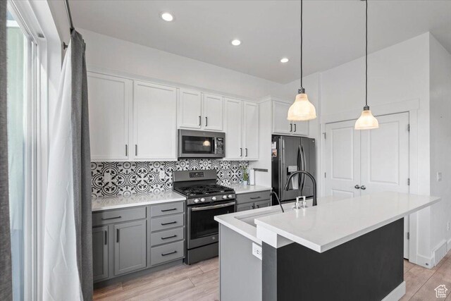 5233 W Linley Ct, Herriman, UT 84096 - kitchen featuring appliances with stainless steel finishes, gray cabinets, backsplash, light wood-type flooring, and recessed lighting
