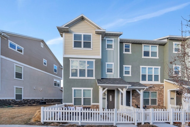 townhome / multi-family property featuring a fenced front yard and stucco siding