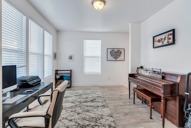 office space with baseboards and light wood-type flooring