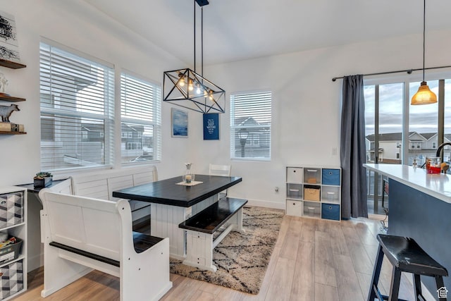 dining area with light wood-style floors, a notable chandelier, and a wealth of natural light