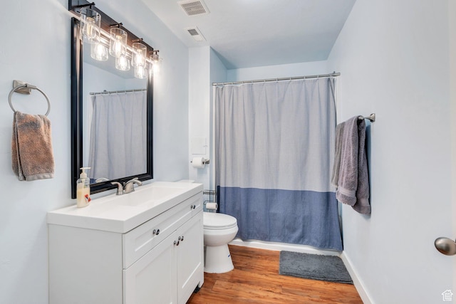 full bath featuring vanity, toilet, wood finished floors, and visible vents