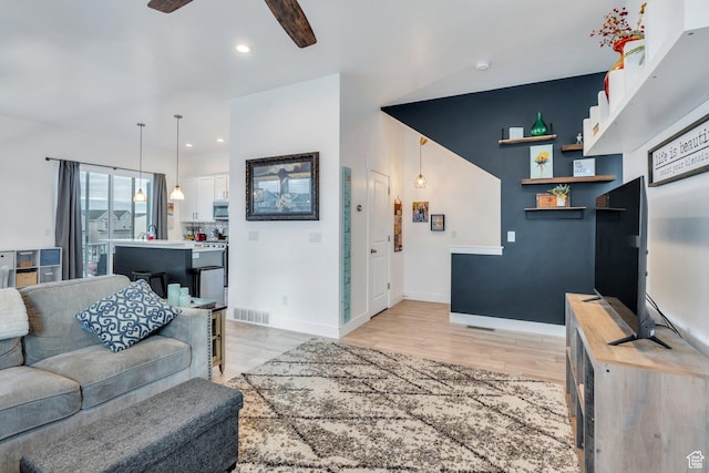 living room with ceiling fan, visible vents, light wood-type flooring, baseboards, and recessed lighting