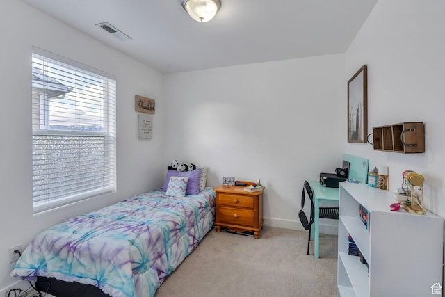 bedroom with baseboards, light carpet, and visible vents