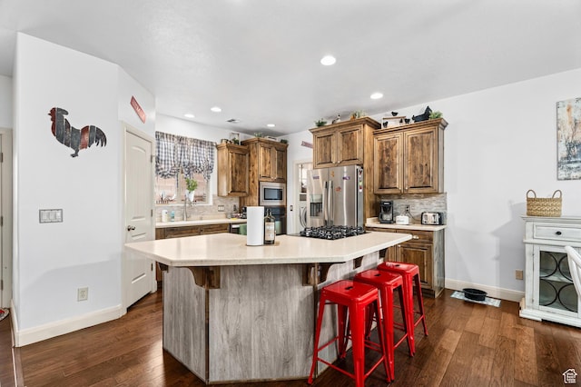 78 W Jolley Cir, Washington, UT 84780 - kitchen with light countertops, appliances with stainless steel finishes, brown cabinetry, and dark wood finished floors