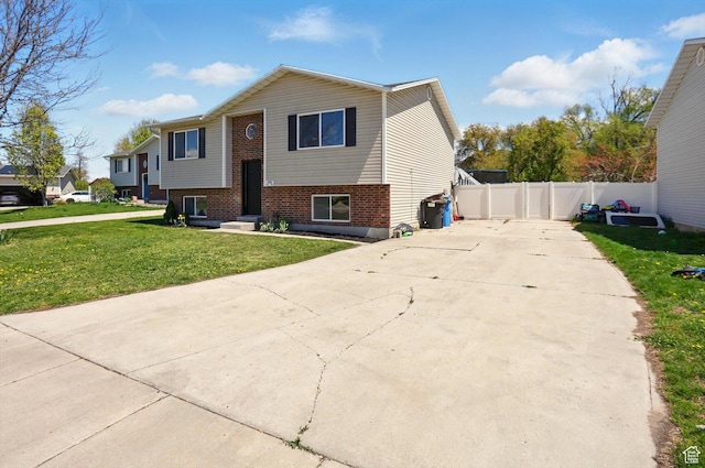 680 S Riverwalk Pkwy W, Logan, UT 84321 - view of front of property featuring concrete driveway, brick siding, fence, and a front lawn