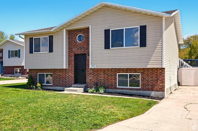 680 S Riverwalk Pkwy W, Logan, UT 84321 - split foyer home with concrete driveway, a front lawn, and brick siding