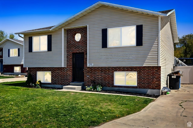bi-level home with brick siding and a front lawn