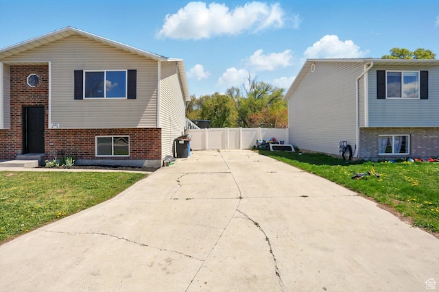 680 S Riverwalk Pkwy W, Logan, UT 84321 - view of home's exterior featuring brick siding, fence, a yard, and driveway