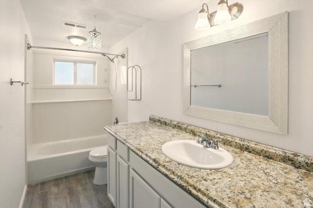 680 S Riverwalk Pkwy W, Logan, UT 84321 - bathroom featuring visible vents, vanity, wood finished floors, toilet, and washtub / shower combination