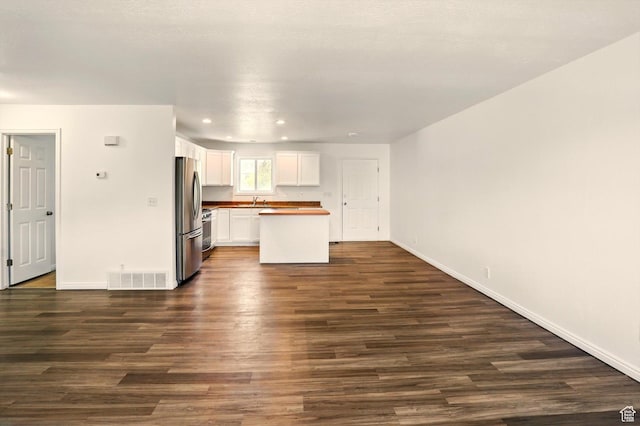 680 S Riverwalk Pkwy W, Logan, UT 84321 - unfurnished living room featuring visible vents, recessed lighting, baseboards, and dark wood-style floors