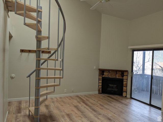 6871 N 2200 W Unit 8L, Park City, UT 84098 - unfurnished living room featuring stairs, a ceiling fan, wood finished floors, and a fireplace