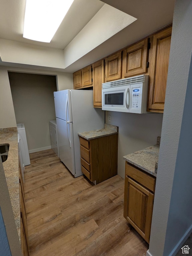6871 N 2200 W Unit 8L, Park City, UT 84098 - kitchen featuring light wood-style floors, brown cabinetry, white appliances, and washing machine and clothes dryer