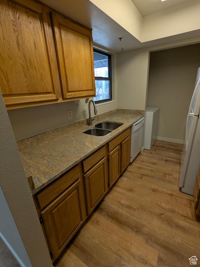 6871 N 2200 W Unit 8L, Park City, UT 84098 - kitchen with brown cabinetry, washer / clothes dryer, a sink, light wood finished floors, and white appliances