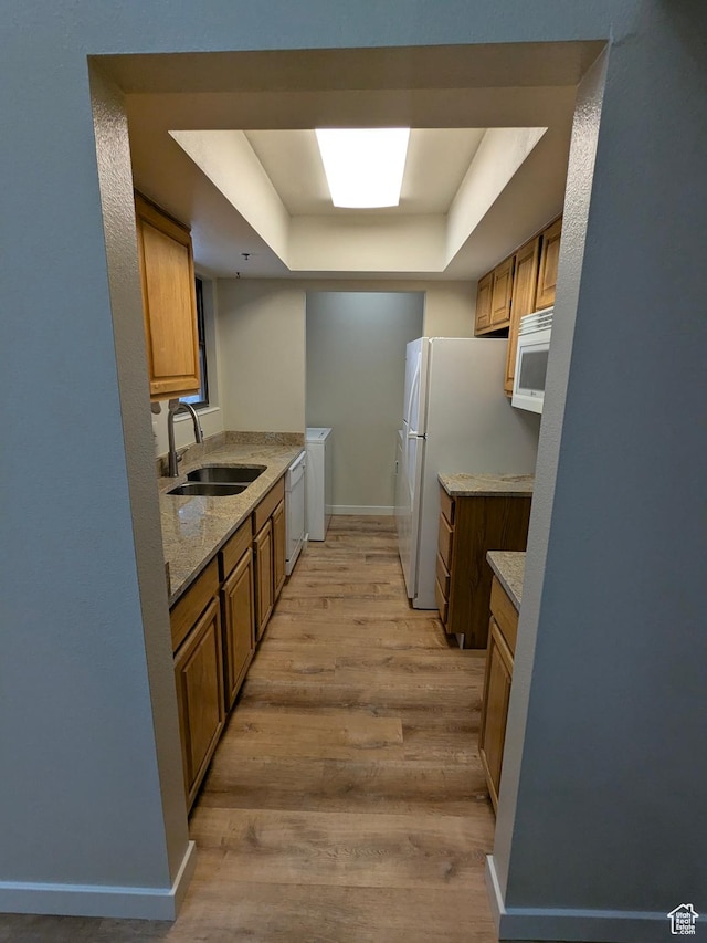 6871 N 2200 W Unit 8L, Park City, UT 84098 - kitchen featuring brown cabinetry, white appliances, a raised ceiling, a sink, and light wood finished floors