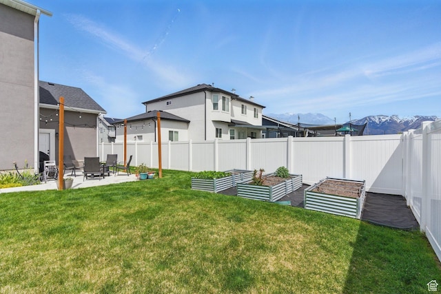 2471 W Anne Ave, West Haven, UT 84401 - view of yard featuring a mountain view, fence private yard, a vegetable garden, and a patio
