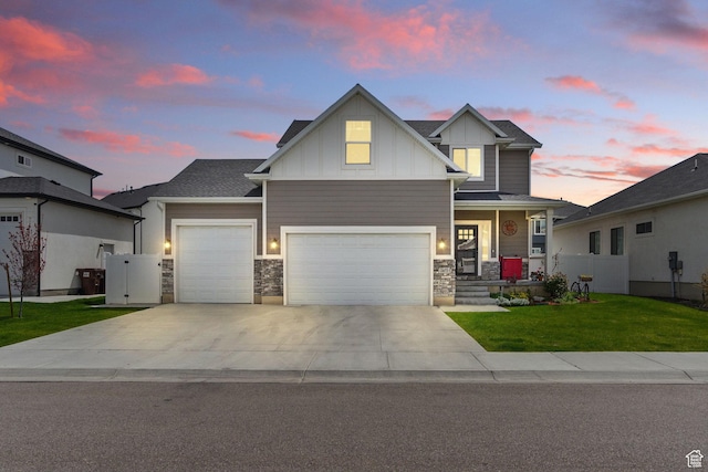 craftsman inspired home with an attached garage, stone siding, board and batten siding, a yard, and driveway