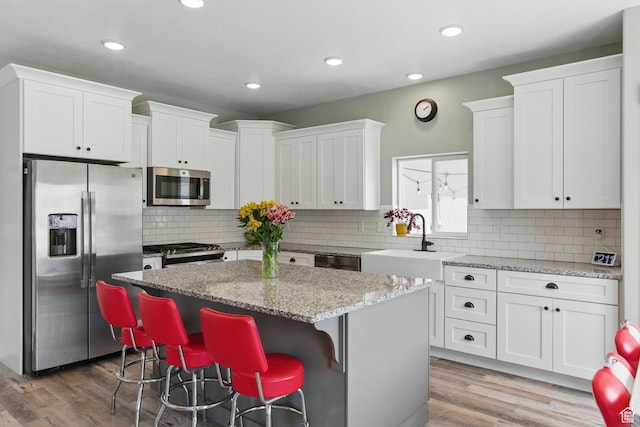 2471 W Anne Ave, West Haven, UT 84401 - kitchen with a sink, appliances with stainless steel finishes, a center island, and white cabinetry