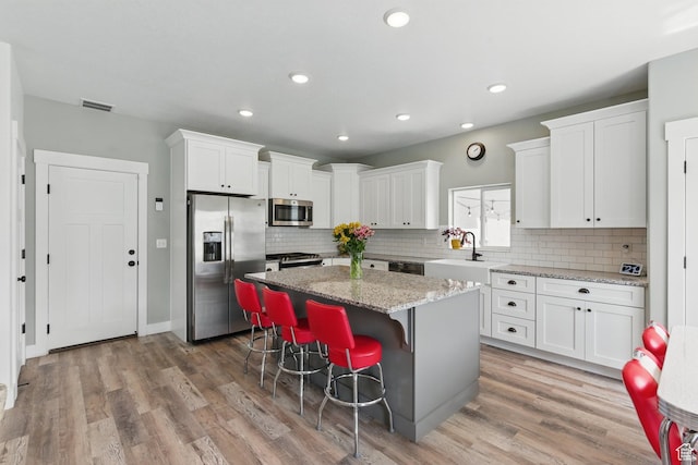 2471 W Anne Ave, West Haven, UT 84401 - kitchen featuring visible vents, a center island, a sink, white cabinets, and stainless steel appliances