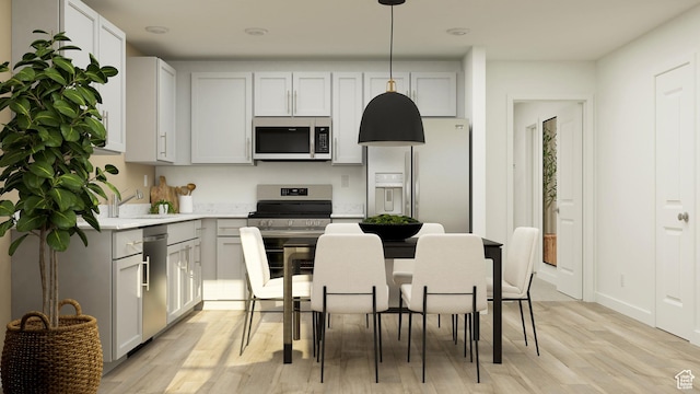 207 N Madison Ave E Unit 124, Santaquin, UT 84655 - kitchen featuring appliances with stainless steel finishes, light wood finished floors, light countertops, decorative light fixtures, and a sink