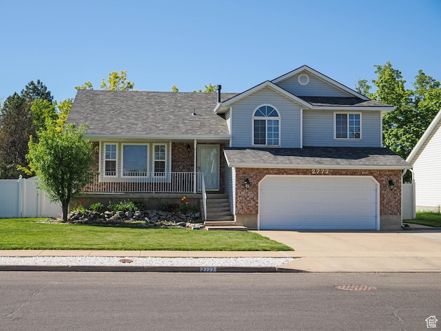 2777 W 1100 N, Layton, UT 84041 - split level home with a front lawn, fence, covered porch, an attached garage, and driveway