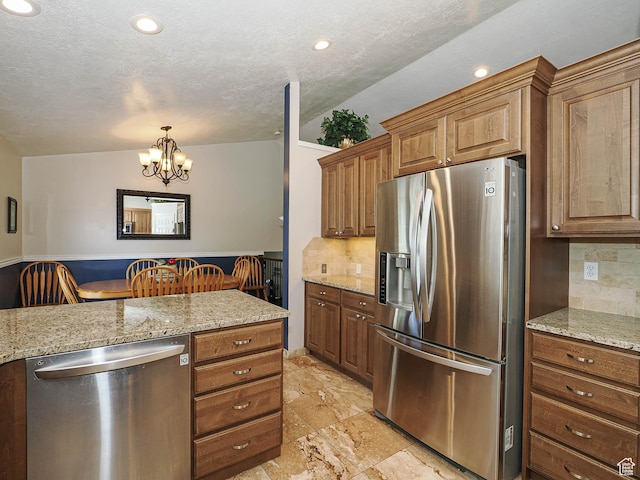 2777 W 1100 N, Layton, UT 84041 - kitchen featuring brown cabinets, a chandelier, appliances with stainless steel finishes, and decorative backsplash