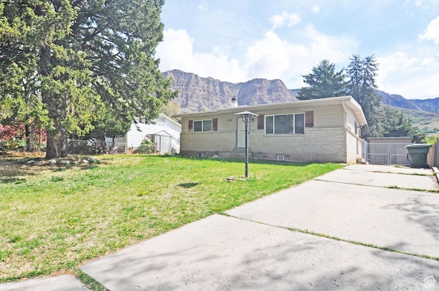 536 S Brinker E, Ogden, UT 84404 - view of front of home featuring an outdoor structure, brick siding, a mountain view, and a front lawn
