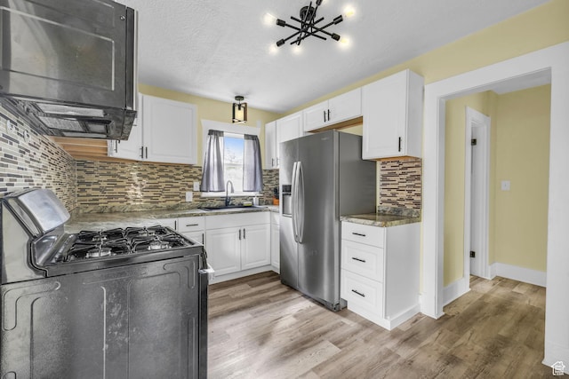 3485 S Grant Ave, Ogden, UT 84403 - kitchen with white cabinets, stainless steel fridge, a sink, tasteful backsplash, and gas range oven