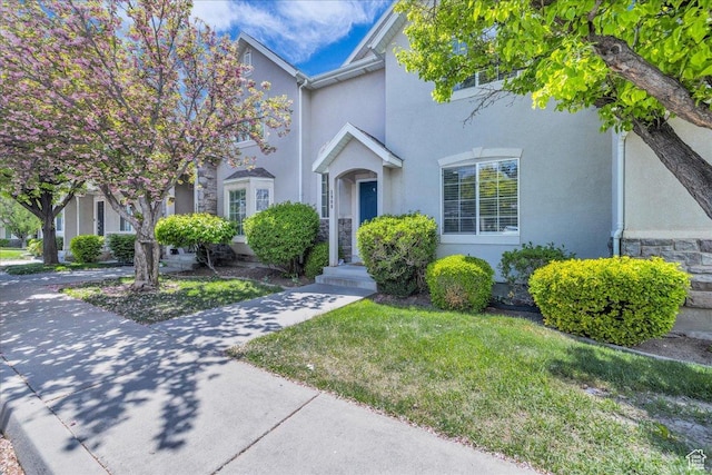 3909 N Davencourt Loop, Lehi, UT 84043 - view of front of home with stucco siding, a front yard, and stone siding