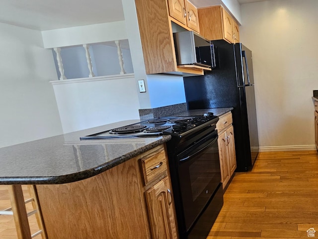 302 E 1400 N, Bountiful, UT 84010 - kitchen featuring black / electric stove, stainless steel microwave, light wood finished floors, a peninsula, and dark stone countertops