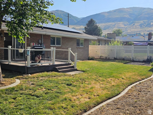 302 E 1400 N, Bountiful, UT 84010 - back of house featuring brick siding, a fenced backyard, solar panels, and a deck with mountain view