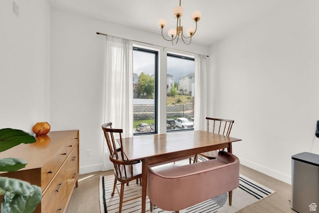 14348 S Champ Cv, Draper, UT 84020 - dining area with baseboards, a chandelier, and light wood-type flooring