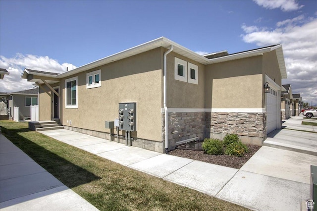 200 W 1200 S Unit 61, Tremonton, UT 84337 - view of property exterior featuring a garage, stucco siding, and stone siding