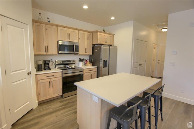 200 W 1200 S Unit 61, Tremonton, UT 84337 - kitchen featuring light wood finished floors, light brown cabinets, a breakfast bar, and stainless steel appliances