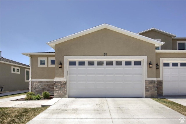 view of front of property with stucco siding, stone siding, and concrete driveway