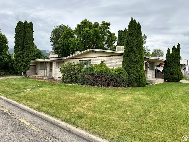 98 W 600 N, Logan, UT 84321 - view of side of property featuring a lawn, a chimney, and brick siding