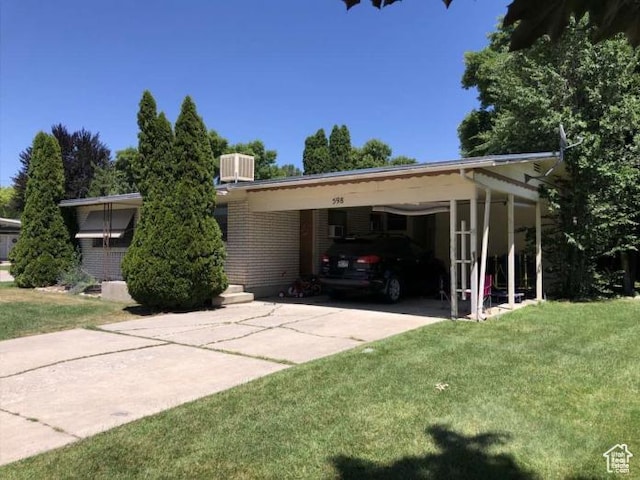 98 W 600 N, Logan, UT 84321 - view of front of house featuring a front yard, brick siding, concrete driveway, central air condition unit, and a carport