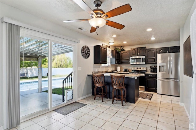 121 N 3000 W, West Point, UT 84015 - kitchen featuring baseboards, a peninsula, light tile patterned flooring, and stainless steel appliances