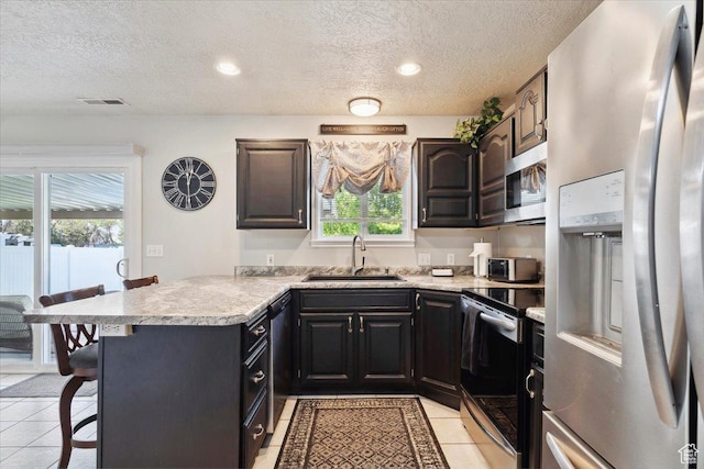 121 N 3000 W, West Point, UT 84015 - kitchen with visible vents, a peninsula, a textured ceiling, a sink, and appliances with stainless steel finishes