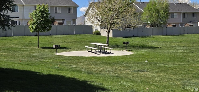 view of community with a lawn, fence, and a patio