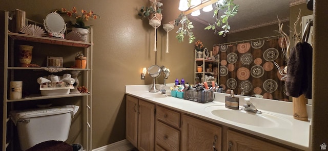 full bathroom featuring double vanity, toilet, curtained shower, and a sink