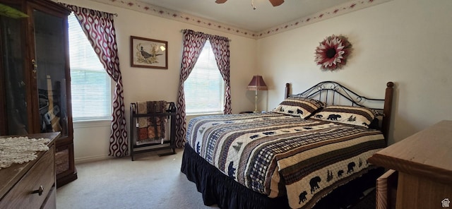 bedroom featuring ceiling fan, multiple windows, baseboards, and light carpet