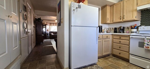 kitchen with white appliances, light countertops, under cabinet range hood, and light brown cabinets