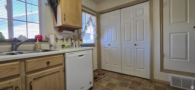 kitchen featuring visible vents, white dishwasher, a sink, and light countertops
