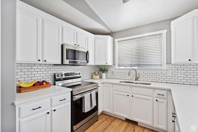 1090 N 3450 W, Layton, UT 84041 - kitchen with appliances with stainless steel finishes, tasteful backsplash, a sink, light countertops, and white cabinetry