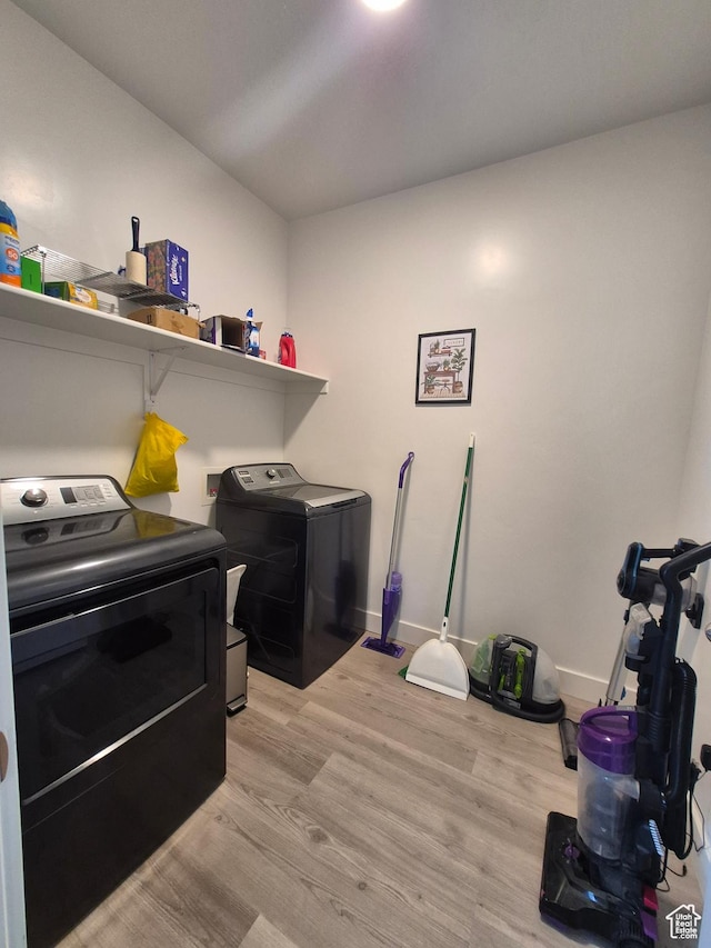 laundry room with baseboards, laundry area, light wood-type flooring, and independent washer and dryer