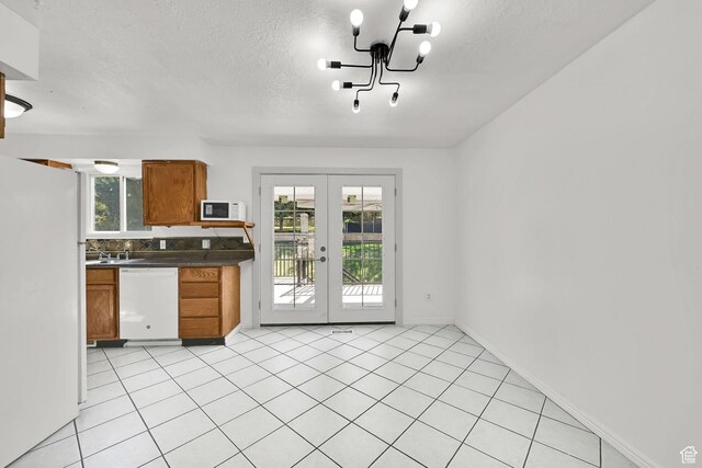 4522 S 2675 W, Roy, UT 84067 - kitchen featuring brown cabinetry, dark countertops, white appliances, a textured ceiling, and french doors